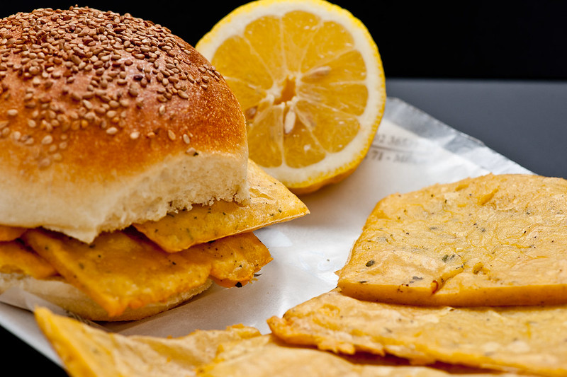 a dish of bread and panelle with a slice of lemon